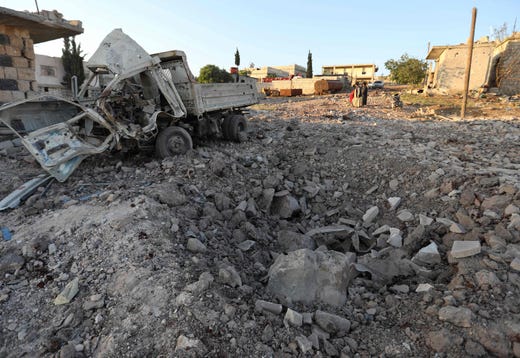 TOPSHOT - A damaged vehicle lies next to a crater cased by reported airstrikes by the Syrian regime ally Russia, in the town of Kafranbel in the rebel-held part of the Syrian Idlib province on May 20, 2019. - According to a war monitor, air strikes by regime ally Russia resumed on the Idlib region late yesterday, after shelling and rocket fire by regime forces earlier in the day killed six civilians. (Photo by OMAR HAJ KADOUR / AFP)OMAR HAJ KADOUR/AFP/Getty Images ORIG FILE ID: AFP_1GO4CB