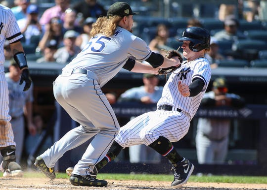 Rays pitcher Ryne Stanek tags out Yankees outfielder Clint Frazier at home plate.