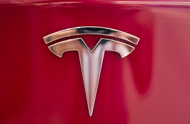 This Wednesday, Aug. 8, 2018, file photo shows the Tesla emblem on the back end of a Model S in the Tesla showroom in Santa Monica, Calif.