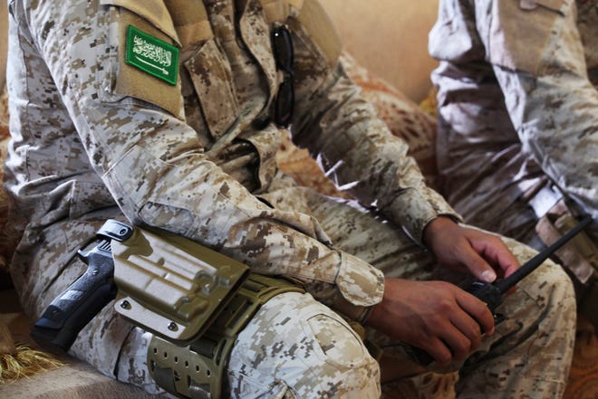 In this Nov. 28, 2018, file photo, an armed Saudi soldier holds a walkie-talkie near Mukalla, Yemen, at an airport now serving as a military base for the United Arab Emirates.