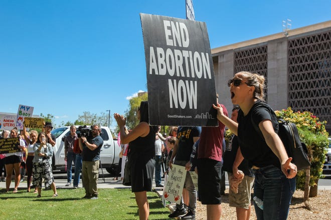 Counterprotesters hold signs as abortion-rights activists gather at a rally to protest abortion bans at Arizona state Capitol in Phoenix on May 21, 2019.
