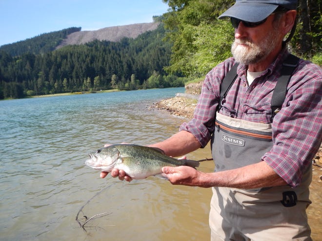 Randy Wildman holds a largemouth bass he caught in Fall Creek Reservoir.