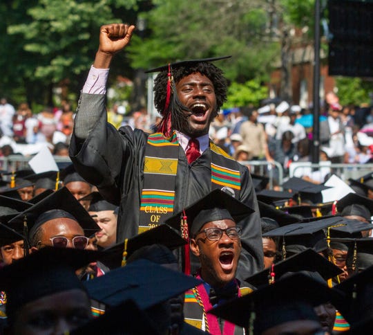 Graduates react after hearing billionaire technology investor and philanthropist Robert F. Smith say he will provide grants to wipe out the student debt of the entire 2019 graduating class at Morehouse College in Atlanta, Sunday, May 19, 2019. (Steve Schaefer/Atlanta Journal-Constitution via AP) ORG XMIT: GAATJ901