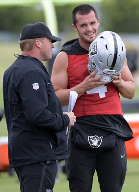 Oakland Raiders coach Jon Gruden talks to quarterback Derek Carr during organized team activities.