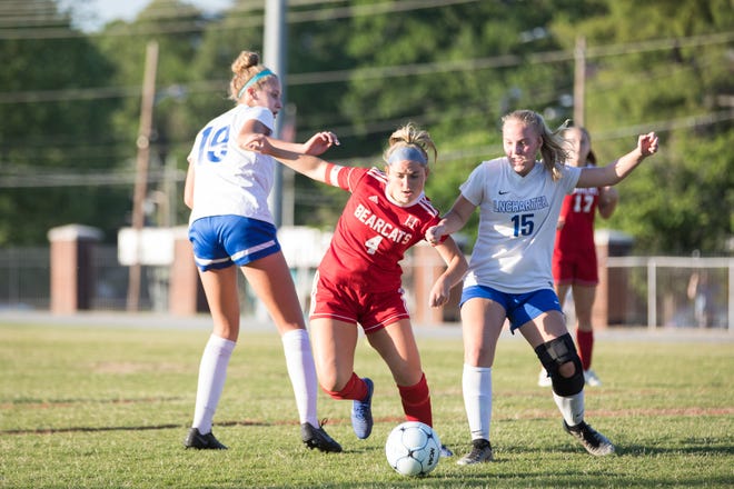 Hendersonville's Eden Hawkins (4) moves the ball past two defenders in the Western Championship game against Lake Norman Charter School on May 21, 2019, at Hendersonville High School. (www.BlueRidgeExpressions.com)