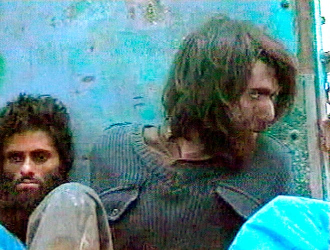 This file image taken Dec. 1, 2001, from television footage in Mazar-i-Sharif, Afghanistan, shows John Walker Lindh, right, claiming to be an American Taliban volunteer. Lindh, the young Californian who became known as the American Taliban after he was captured by U.S. forces in the invasion of Afghanistan in late 2001, is set to go free Thursday, May 23, 2019, after nearly two decades in prison.