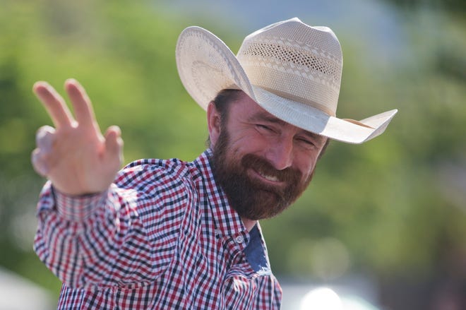 In this July 4, 2018 photo Utah County Commissioner Nathan Ivie waves during the Freedom Festival's Grand Parade in Provo, Utah. The Republican lawmaker in a heavily-Mormon area of Utah has publicly come out as gay. Ivie said his announcement, Wednesday, May 22, 2019, was inspired in part by his work with families who have lost gay children to suicide. (Evan Cobb/The Daily Herald via AP)