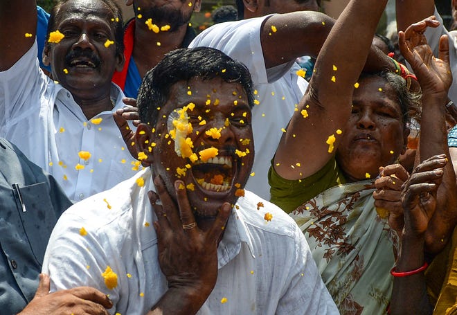 Indian members of the Dravida Munnetra Kazhagam (DMK) eat and dance as they celebrate on the vote results day for India's general election at the party headquarters in Chennai on May 23, 2019. - Indian Prime Minister Narendra Modi looked on course on May 23 for a major victory in the world's biggest election, with early trends suggesting his Hindu nationalist party will win a bigger majority even than 2014.