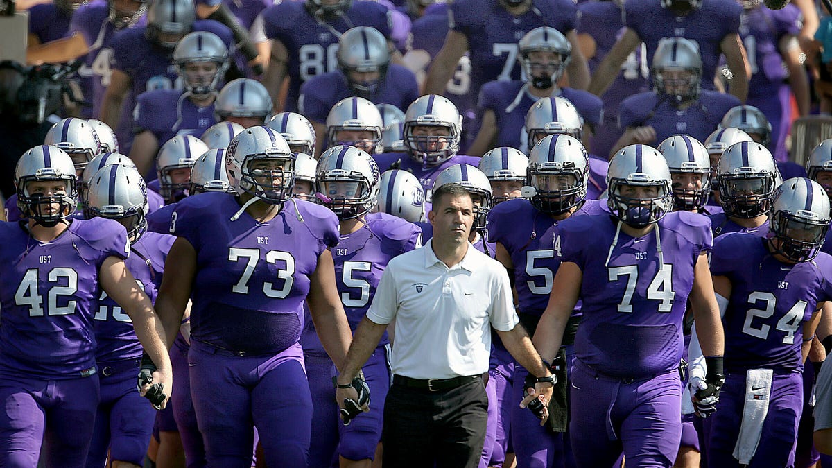 FILE - In this Sept. 27, 2014, file photo, St. Thomas coach Glen Caruso leads his team onto the field for a college football game against St. John's, in St. Paul, Minn.