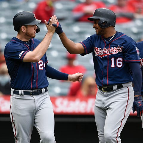 Twins second baseman Jonathan Schoop, center,...