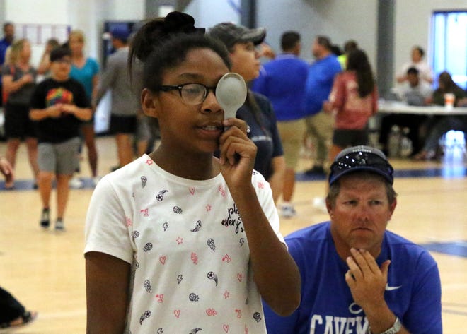 Tuynisha Green, 12, takes the eye exam on Thursday evening at the Carlsbad High gymnasium. CHS provided free physicals to all students in preparation for the upcoming school year.