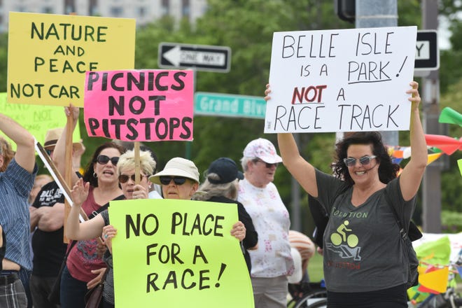 Members of Belle Isle Concern members carry signs on Saturday in opposition to the Grand Prix race being held on Belle Isle.
