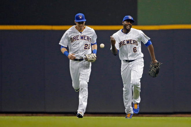 The Brewers' Lorenzo Cain (right) smiles with Christian Yelich after making a catch at the wall to end the fifth inning.