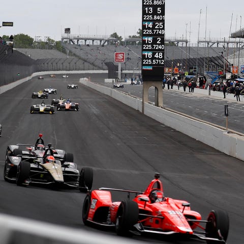 Marco Andretti, front, leads a pack of cars down...