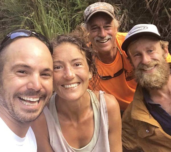 Amanda Eller, second from left, poses for a photo Friday after being found by searchers, Javier Cantellops, far left,  Troy Jeffrey Helmer and Chris Berquist above the Kailua reservoir in East Maui, Hawaii.