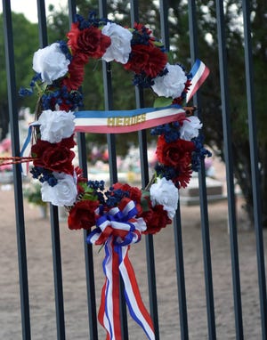 A wreath is hung on the gate entrance to St. Joseph's Cemetery on Sunday, May 26, 2019, the day before Memorial Day, in honor veterans buried there.