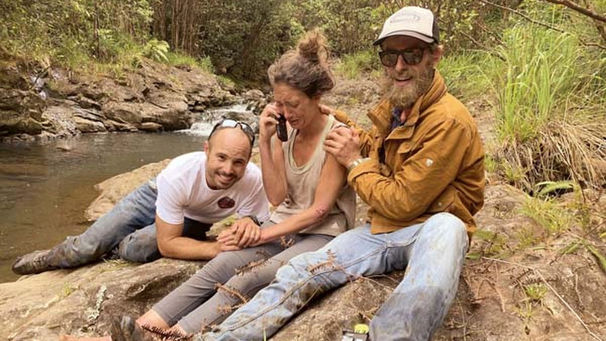 In this Friday, May 24, 2019, photo provided by Troy Jeffrey Helmer, shows Amanda Eller, second from left, after being found by searchers, Javier Cantellops, far left, and Chris Berquist, right, above the Kailua reservoir in East Maui, Hawaii, on Friday afternoon. The men spotted Eller from a helicopter and went down to retrieve her. She was taken to the hospital and was in good spirits, her family said. Eller had been missing since May 8. 