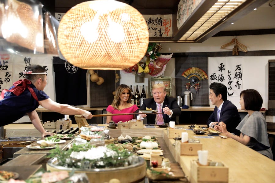 U.S. President Donald Trump is served a baked potato while sitting at a counter with US First Lady Melania Trump, Shinzo Abe, Japan's prime minister and Akie Abe, wife of Shinzo Abe, during a dinner at the Inakaya restaurant in the Roppongi district of Tokyo on May 26, 2019.