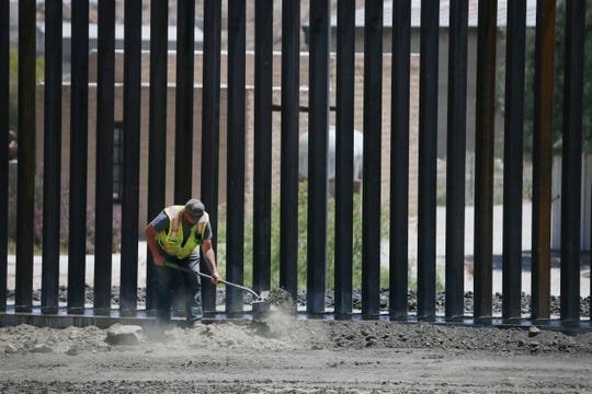 Workers work on a wall being built by Monument One, an official marker at the spot where New Mexico, Texas and the Mexican state of Chihuahua converge, by Border Highway West, near Executive Center Boulevard Monday, May 27, by "We Build the Wall" organization on land owned by American Eagle Brick Company.