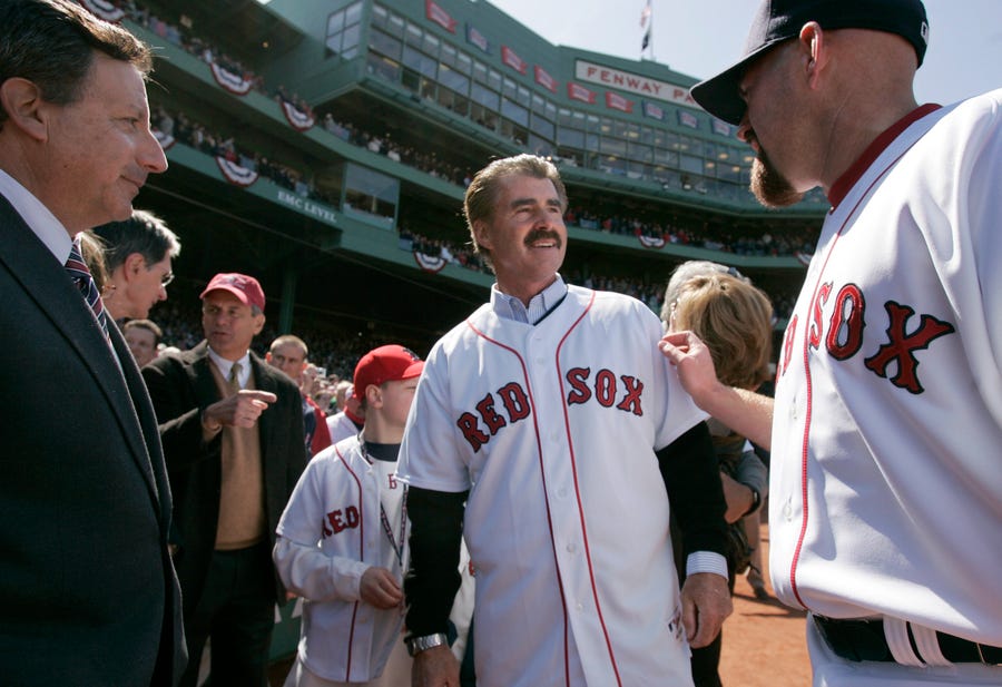 Bill Buckner, center, is greeted by Red Sox's Kevin Youkilis, right, and Red Sox Chairman and co-owner Tom Werner, left, at Fenway Park during the 2008 home-opener.