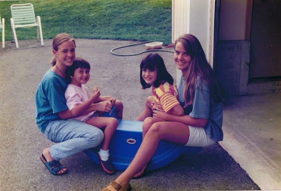 Emily Welch, left, sits on her sister Kristin Long's lap with two of their other sisters.