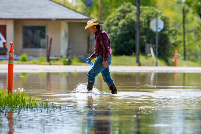 In 2019, Bruce Lee of Sun River wades through high water to visit neighbors. The National Weather Service says flooding on rivers flowing from the Rock Mountain Front is possible in the next day or two depending on where it rains and how much.