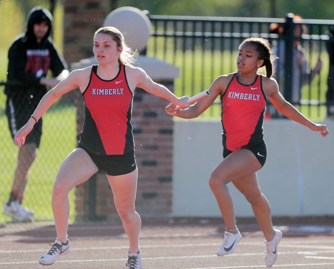 Kimberly's Amaija Powell hands the baton to Taylor Hietpas in the 800-meter relay at a WIAA Division 1 track and field sectional in De Pere on May 23.