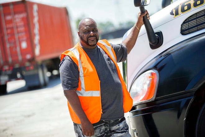 In this Wednesday, May 22, 2019 photo, Leon Brown stands by his tractor-trailer after making a delivery from a distribution center to the Port of Savannah, in Garden City, Ga. Brown is trusted enough to drive a tractor-trailer inside one of the nation's busiest seaports more than six years after being released from prison. But he's not allowed to vote in Georgia because of a law rooted in the years after the Civil War when whites sought to keep blacks from the ballot box.
