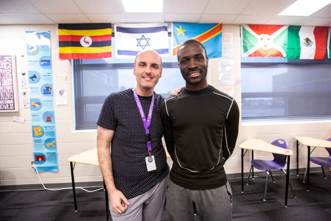 Héritier Otiom poses for a photo with teacher Daniel Lekin, left, Tuesday, May 21, 2019, at Liberty High School in North Liberty, Iowa.