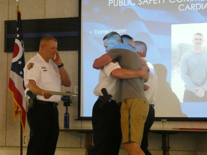 Newark police Deputy Chief Darrin Logan embraces his son, Daniel Logan, at the annual Newark Division of Police Awards Presentation on Wednesday, May 29, 2019. Chief Barry Connell wipes his cheek, preparing to hand Daniel Logan a certificate for saving his father's life during a heart attack earlier this year.