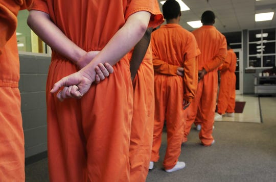 Residents stand in line for breakfast at a juvenile detention facility.