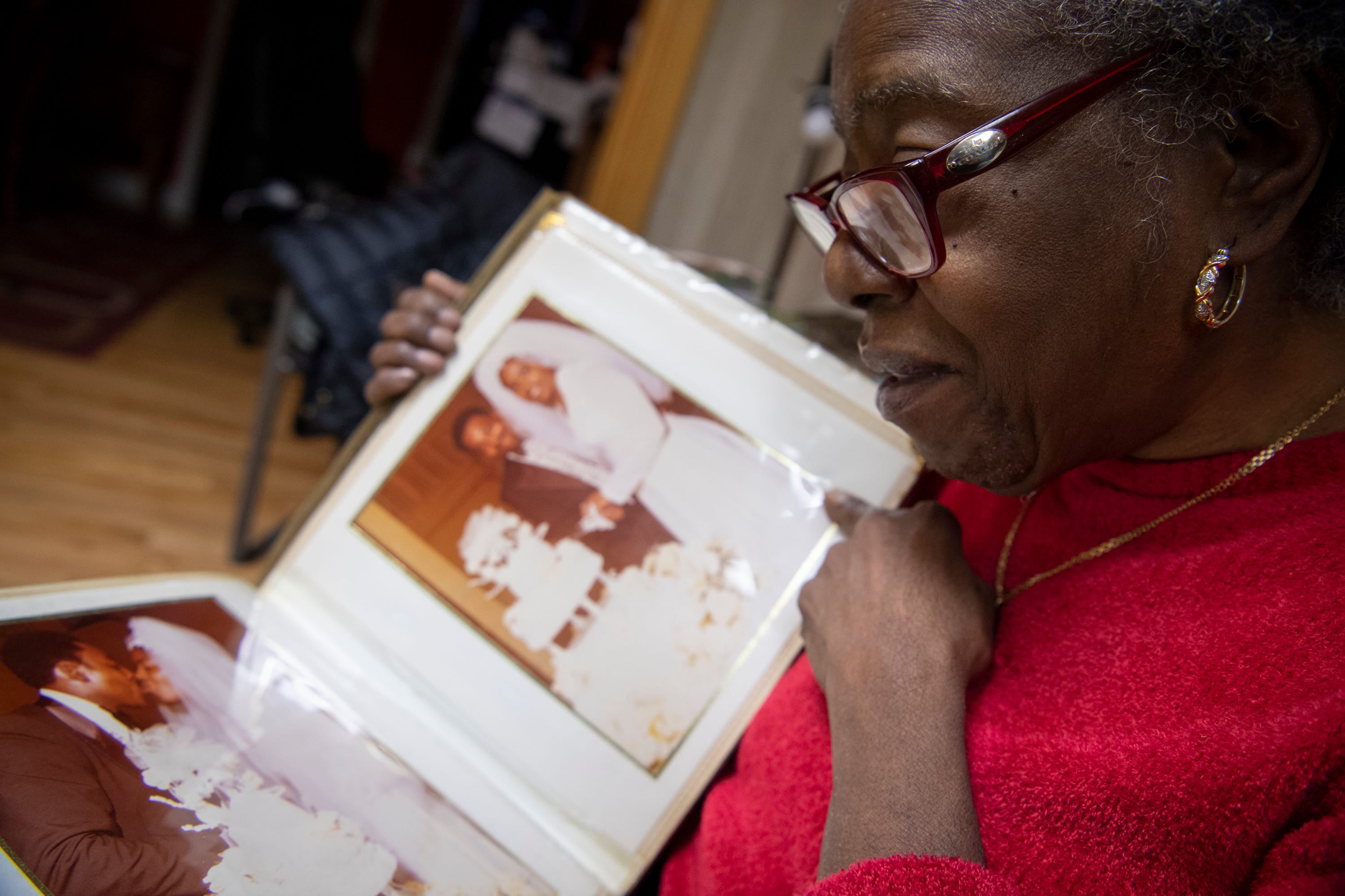 Patricia Blair is overcome with emotion as she looks through her wedding photo album in the living room of her home. 