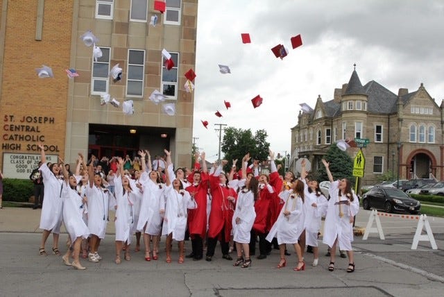 St. Joseph Central Catholic High School graduates toss their caps at graduation.