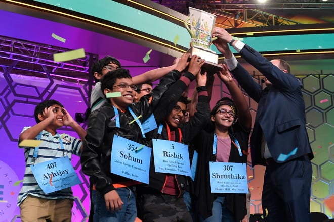 Abhijay Kodali, 12, of Flower Mound, Texas; Sohum Sukhatankar, 13, of Dallas; Rishik Gandhasri, 13, of San Jose, Calif.; Shruthika Padhy, 13, of Cherry Hill, N.J., and the other winning spellers gather at the end of the 2019 Scripps National Spelling Bee in Oxon Hill, Md., early Friday, May 31, 2019. The bee ended in an unprecedented 8-way championship tie.