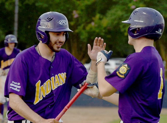 Conner Castille, left, is congratulated by St. Landry Bank Indians teammate Jobee Boone after scoring during the first inning of Thursday's game with the Opelousas General Health System Warriors.