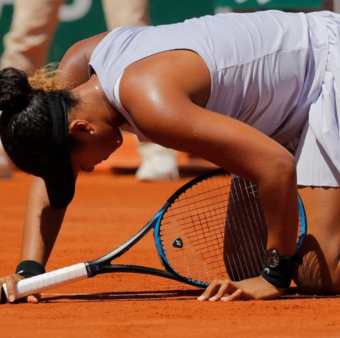 Naomi Osaka gets up after slipping during her...