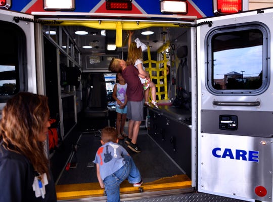 Cord Adkins, 8, lifts his 3-year-old sister Rynn so she can touch the ceiling of a Metro Care ambulance Saturday at Hendrick Medical Center.