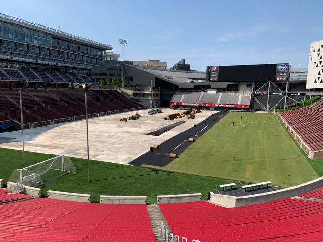 Contractors install a temporary grass surface at the University of Cincinnati's Nippert Stadium Monday, June 3 in preparation for a U.S. men's national team match against Venezuela.