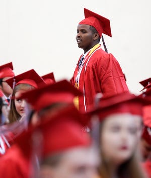 Mohamed Amin Mohamed walks through the rows of Green Bay East High School graduates before the start of the school's commencement ceremony on Sunday at the Kress Center in Green Bay.