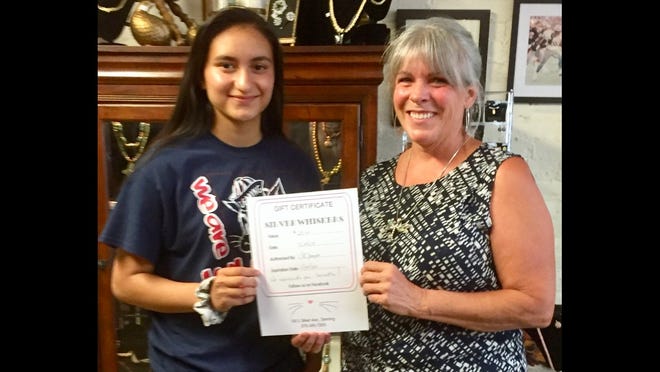 Samantha Jurado, 14, is presented with her gift certificate to Silver Whisker Thrift Store following her rescue of a four-week old kitten. Presenting the gift is Debbie Troyer