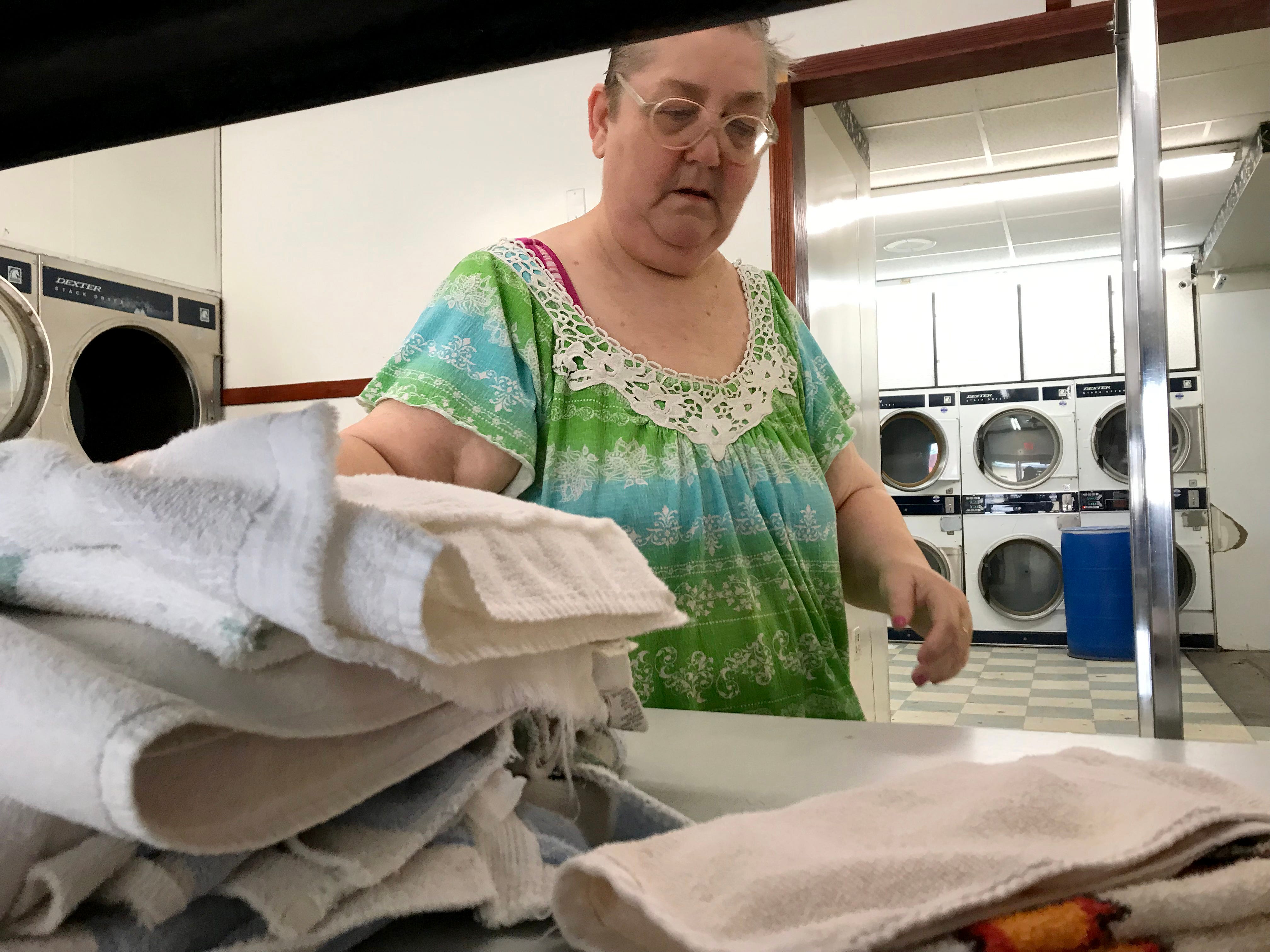 Roxie Cotton folds towels at a laundromat.