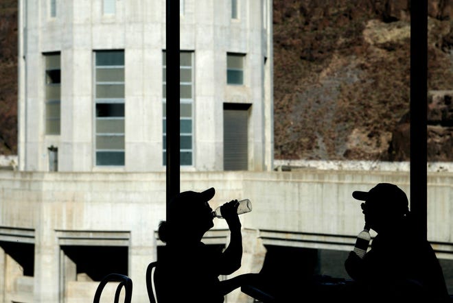 Lena Jankovic, 75, left, and her daughter Diana Jankovic, 35, both of Tampa, Fla., drink what is left of their water in air-conditioned comfort inside a cafe on Wednesday, May 28, 2003, at the Hoover Dam, Nevada.