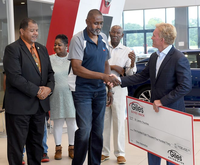 Oscar Walker of St. Mary's Baptist Church in Port Barre, shakes hands with Bob Giles during Thursday's press conference at Giles Nissan in Opelousas. Giles presented the three churches that burned earlier this year with $108,430 to help rebuild following the separate fires. The money was part of a $50,000 funding match that Giles provided from his Giles Gives Back program.