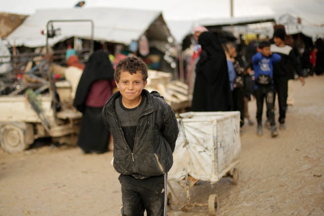 A boy who works as a porter pauses for a portrait in the marketplace at Al-Hol camp, where families from Islamic State-held areas are housed, Hassakeh province, Syria, Sunday, March 31, 2019.