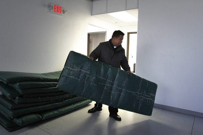 Bill Simon with the Salvation Army pulls out a sleeping mat, Friday, Nov. 6, 2014, at The Roof in Farmington.