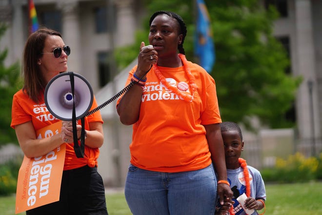 Lanita Brooks speaks about her 17 year-old son DeShon "Poppy" Sellers, who was killed by gun violence, at the Wear Orange rally in Rodney Square in June 2019. Her 5 year-old son Eric Thomas hold her hand.