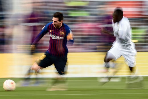 Barcelona's forward Lionel Messi (L) runs with the ball during the Spanish League football match between Barcelona and Getafe at the Camp Nou Stadium in Barcelona on May 12, 2019.