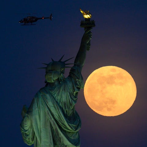 A helicopter flies past as the full moon rises...