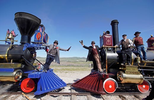 Men reenact the historic Champagne Toast with the Jupiter (L) and the 119 (R) steam engines for the 150th anniversary of the driving of the Golden Spike on May 10, 2019 in Promontory, Utah. The driving of the Golden Spike completed the Transcontinental Railroad that linked both coasts of the United States for the first time.
