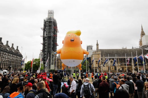 A giant balloon depicting President Trump as an orange baby floats above anti-Trump demonstrators in Parliament Square outside the Houses of Parliament in London on June 4, 2019, on the second day of Trump's three-day State Visit to the UK.